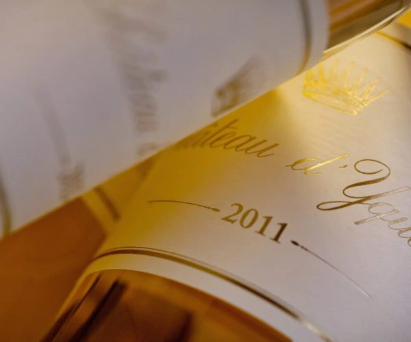 Table de trois restaurants Bordeaux, gros plan sur l'étiquette dorée d'une bouteille de Château d'Yquem 2011, grand vin liquoreux de Bordeaux